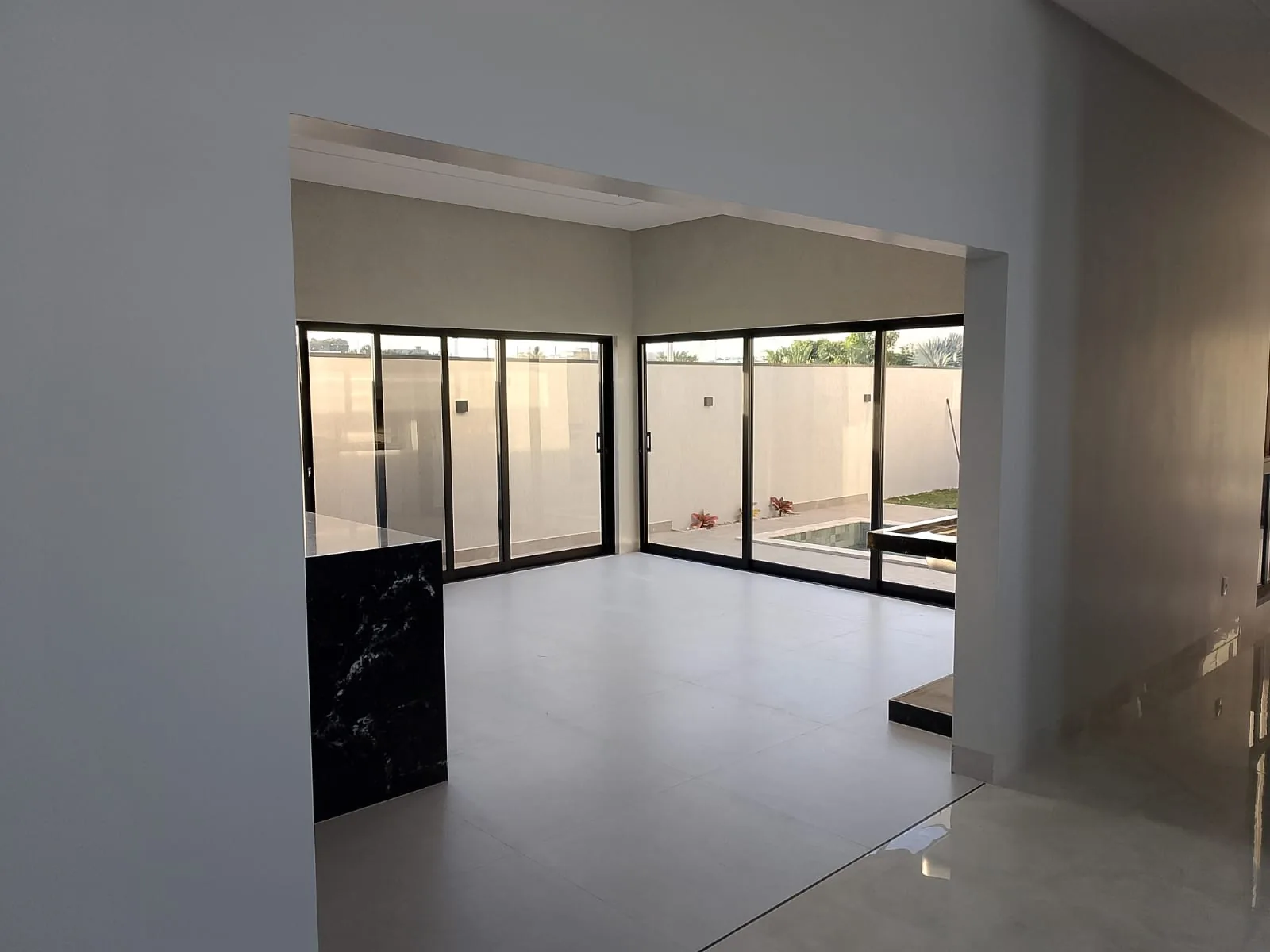 Sala de estar finalizada com piso polido e porta de vidro